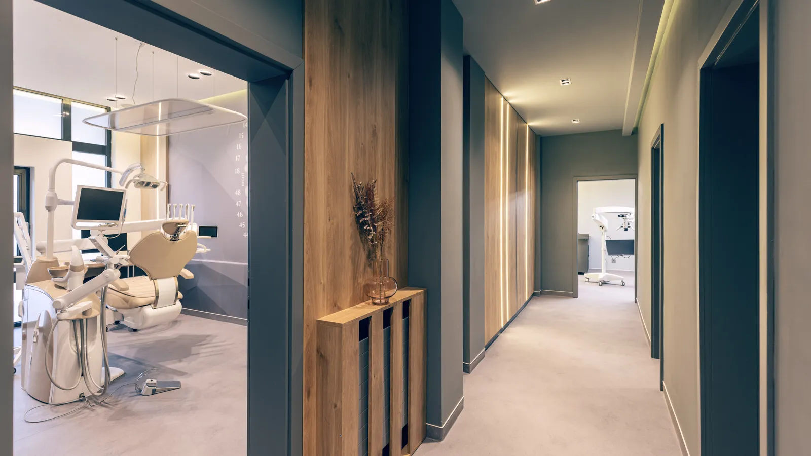 A corridor inside a modern dental practice, with treatment rooms opening off it