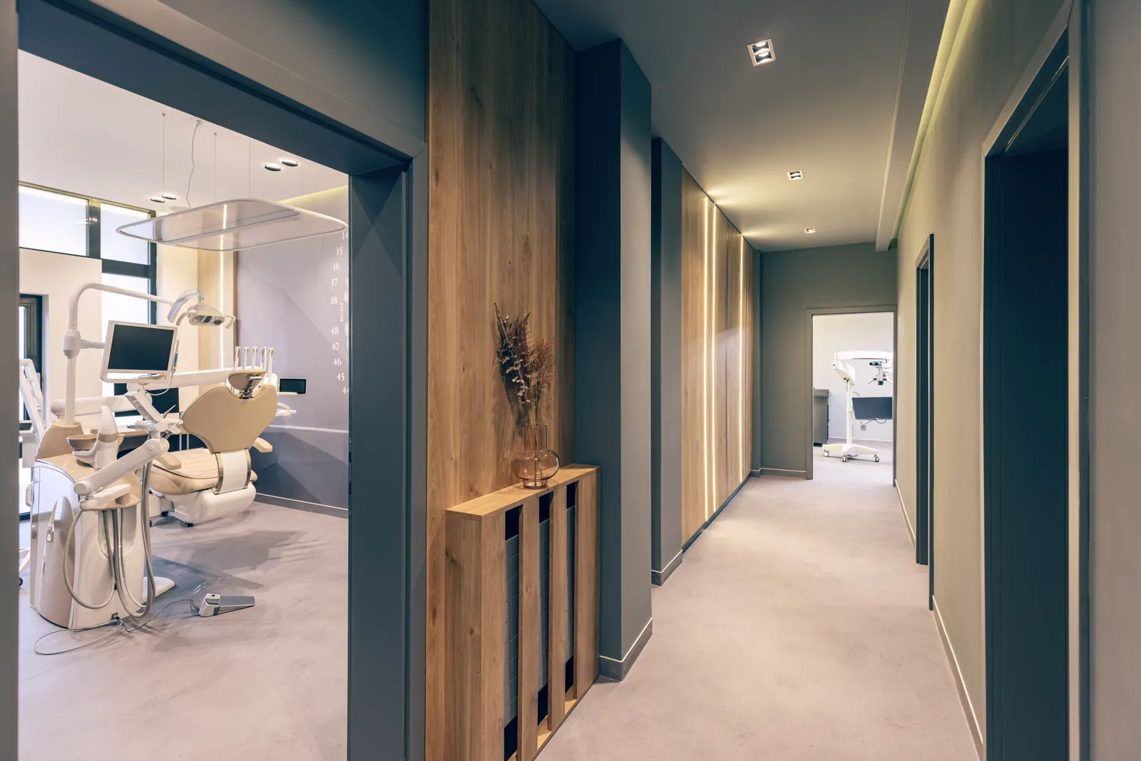 A corridor inside a modern dental practice, with treatment rooms opening off it
